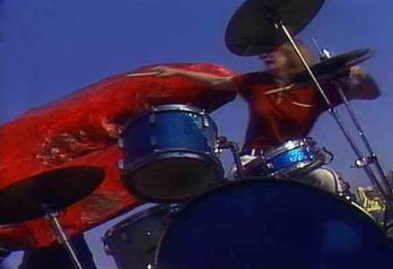 Crystal at the Trixon drumkit being attacked by a mutated lobster in a scene from the cult film 'Lobsteroids'